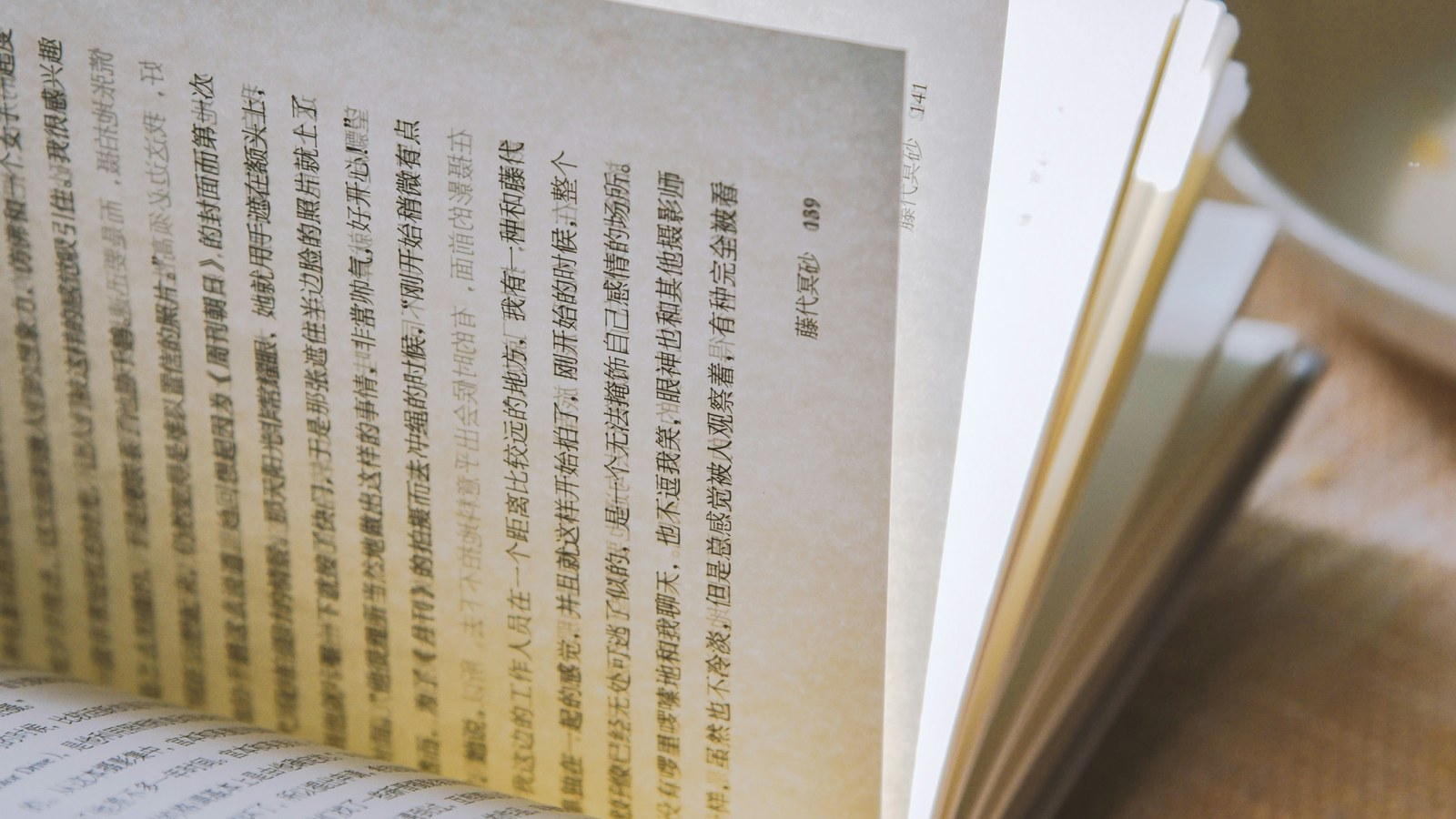 A spiral-bound employee handbook open on a desk with a sticky note marking a page