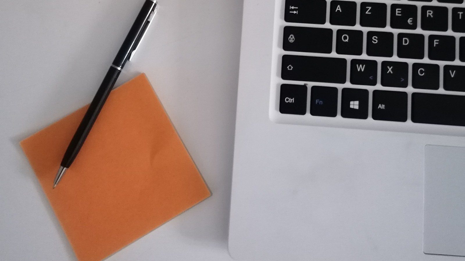 A short typed note on a desk beside a closed laptop