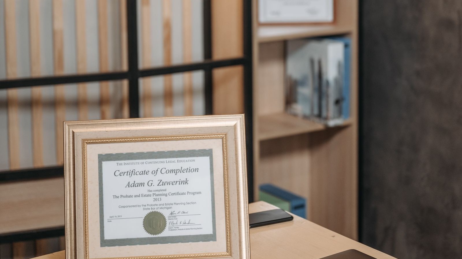 A framed occupational license hanging on a shop wall beside a wall clock